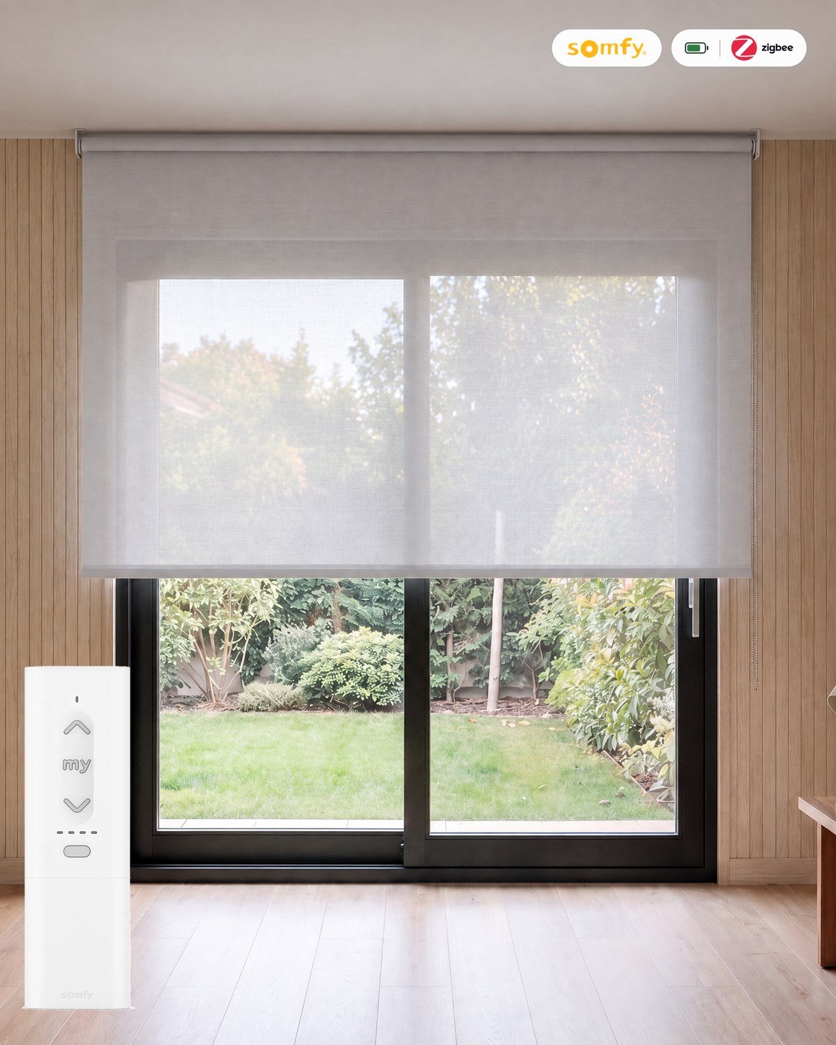 Estor enrollable motorizado screen de poliéster 5% Perla con mando Somfy Zigbee, batería y cargador, en una sala con paneles de madera